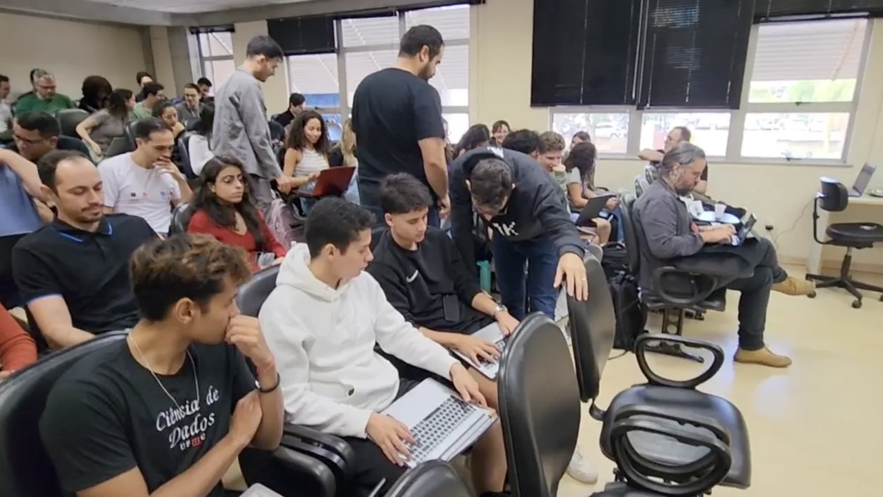 Students working on laptops in a classroom while instructors move between the rows to help
